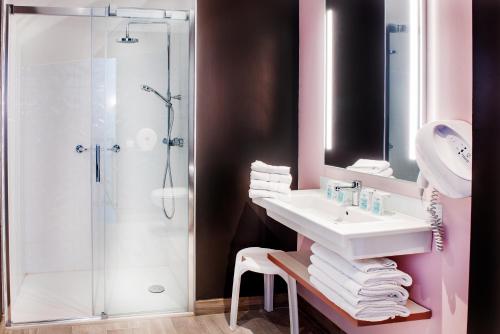 a bathroom with a sink and a shower at Hôtel Sainte-Rose in Lourdes