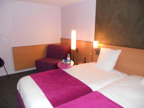 a hotel room with a bed and a chair at ibis Styles Bourg-en-Bresse Centre in Bourg-en-Bresse