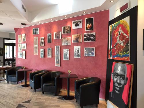 a red wall in a restaurant with chairs and pictures at Hotel Sant'Elia in SantʼElia Fiumerapido