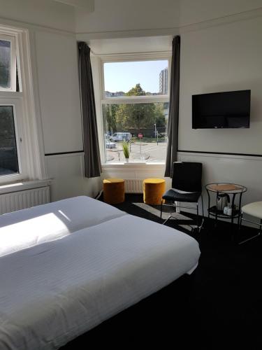 een hotelkamer met een bed en een groot raam bij Stad & Strandhotel Elisabeth in Vlissingen