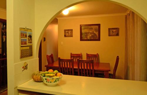 uma cozinha e sala de jantar com uma mesa e uma taça de fruta em Nulla Nulla Farm Retreat em Moorine Rock