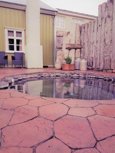 a brick patio with a pool of water in front of a house at Hótel Tindastóll in Sauðárkrókur
