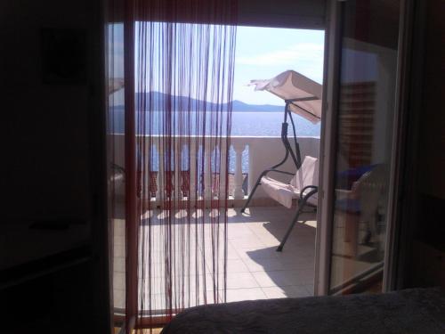 a bedroom with a view of the ocean from a balcony at Apartments Brčić in Sveti Petar