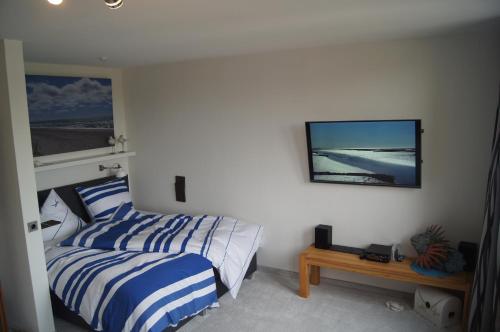 een slaapkamer met een bed en een tv aan de muur bij Apartment Nordenham in Nordenham