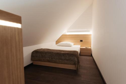 a small bedroom with a bed in a attic at Hotel Ajda Depandance Prekmurska Vas - Terme 3000 - Sava Hotels & Resorts in Moravske Toplice