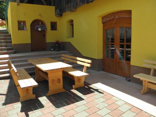 a patio with wooden tables and benches in front of a building at Apartments Tubej in Bohinj