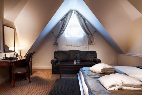 a bedroom with a bed and a chair and a window at Luxury Spa Hotel Olympic Palace in Karlovy Vary