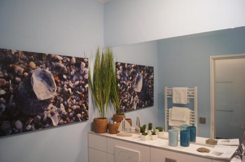 a bathroom with two pictures on the wall and a mirror at Apartment Nordenham in Nordenham