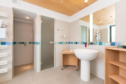 La salle de bains est pourvue d'un lavabo et d'une douche. dans l'établissement Hotel Niedersachsen, à Westerland