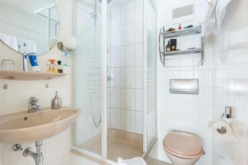 a bathroom with a shower and a toilet and a sink at City Hotel Konstanz in Konstanz