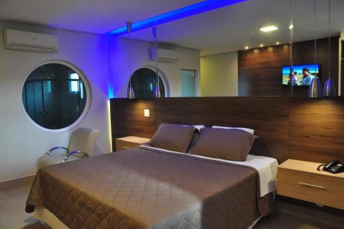 a bedroom with a large bed with purple lighting at Kamur Plaza Hotel in Goianésia