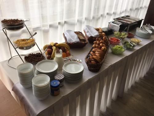 a buffet with plates and food on a table at Hotel Druzba in Michalovce