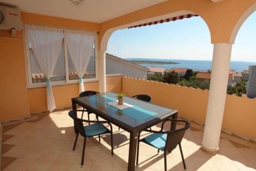 a table and chairs on a balcony with a view of the ocean at Villa Mateja in Novalja