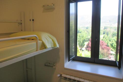 a room with a bed and a window with a view at Alberg la Bruna in Bellver de Cerdanya 