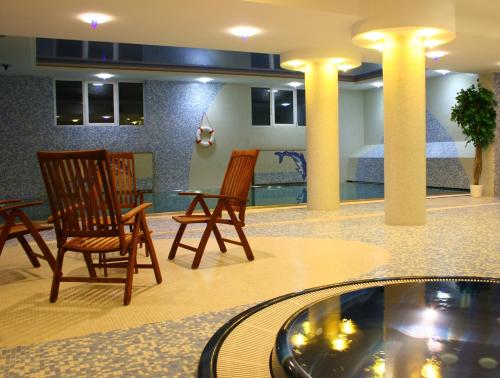 a lobby with chairs and a table and a bed at April hotel Panorama in Rychnov nad Kněžnou