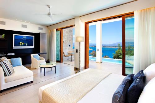 a living room with a view of the ocean at Nafplia Palace Hotel & Villas in Nafplio