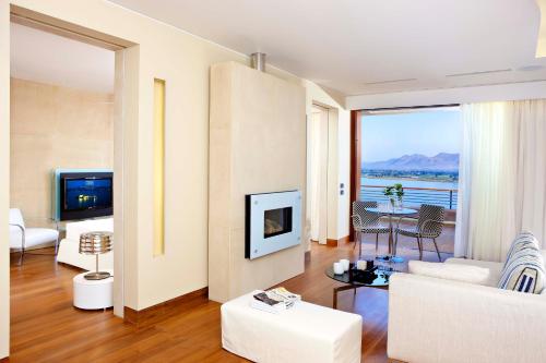 a living room with a couch and a tv at Nafplia Palace Hotel & Villas in Nafplio