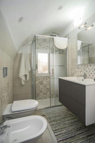 a bathroom with a shower and a sink and a toilet at Fèdeli House City in Noto