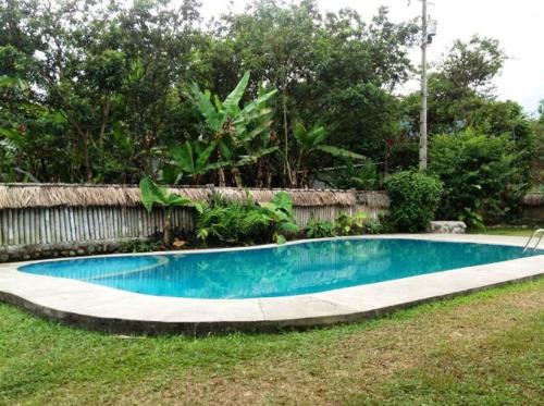 una pequeña piscina en un patio junto a una valla en Hostería Mindo Samay Juku, en Mindo