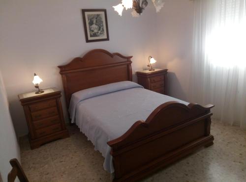 コニル・デ・ラ・フロンテーラにあるApartamento Villamartínのベッドルーム1室(木製ベッド1台、ナイトスタンド2台付)