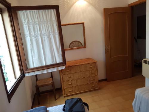 a bedroom with a mirror and a dresser and a window at Mare a Santa Margherita in Pula