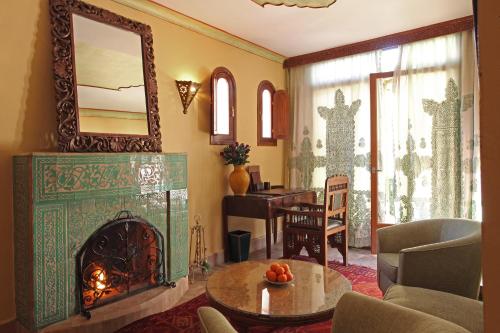 a living room with a fireplace and a mirror at La Maison Arabe Hotel, Spa & Cooking Workshops in Marrakech