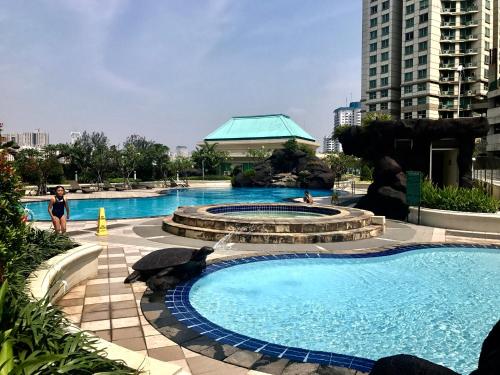 a large swimming pool in a city with buildings at Batavia Apartment ST in Jakarta