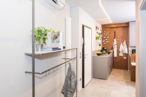 a kitchen with white walls and a sliding glass door at Green Flat in Bardolino