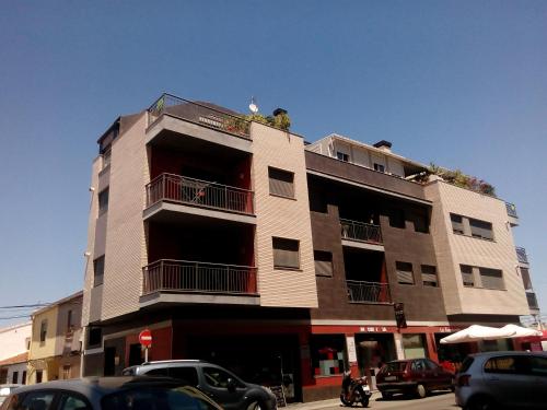 a tall building with cars parked in front of it at Habitacion Familiar en un Ático con gran terraza y,cocina ,en la playa in Burriana