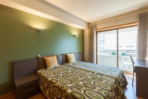 1 dormitorio con cama, escritorio y ventana en Onice Apartment en Oporto