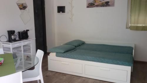 a small bedroom with a bed and a table at "CASABANA" - relax tutto l'anno - giardino - piscina Top in Malcesine