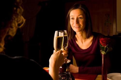 a woman sitting at a table holding a glass of wine at Inch Hotel in Fort Augustus