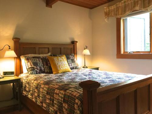 ein Schlafzimmer mit einem Bett, zwei Lampen und einem Fenster in der Unterkunft Cedarwalk in Killington