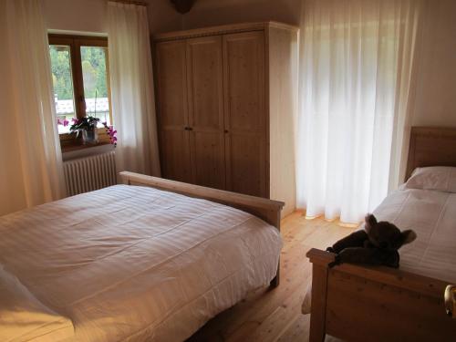 a teddy bear sitting on a bed in a bedroom at Il Cardo Trentino in Bedollo