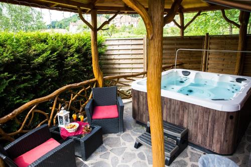 a jacuzzi tub in a gazebo at Domaine du Haut Jardin Hôtel & Chalets Spa Privé in Rehaupal