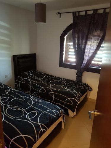 a bedroom with two beds and a window at Appartement B-23 Cabo Négro in Cabo Negro