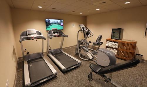 a gym with cardio equipment and a flat screen tv at Beauport Hotel Gloucester in Gloucester