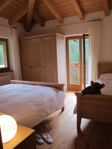 a bedroom with a bed and a cat sitting on a table at Il Cardo Trentino in Bedollo