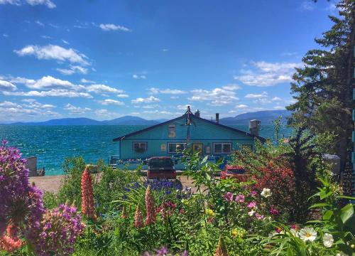 a house on the shore of the water with flowers at The Islander Inn in Bigfork
