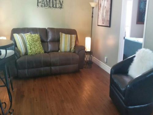a living room with a leather couch and a chair at Secret Cottage Yellowstone 1 bd 2 beds dtwn #1 in Cody