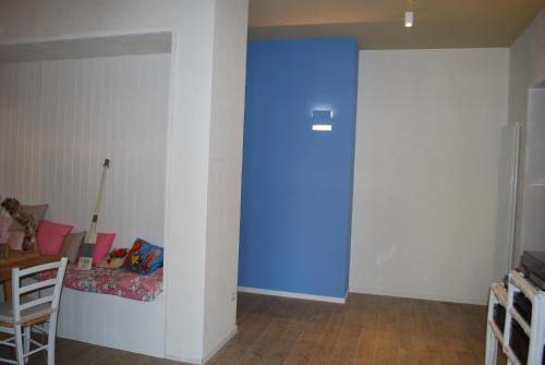a blue door in a room with a table at Casa Polly B&B in Grottammare