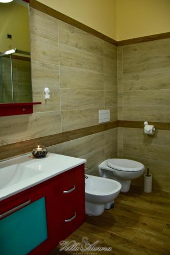 a bathroom with two toilets and a sink and a mirror at Villa Aurora in Villanova del Battista