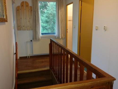 a hallway with a wooden staircase with a window at Konvalinka - ubytování v soukromí in Harrachov
