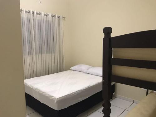 a small bedroom with a bed and a radiator at Recanto Lili in Olímpia
