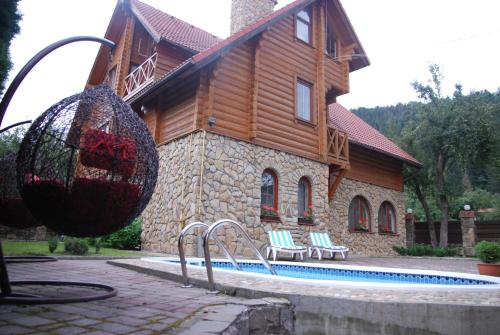 una casa con piscina frente a una casa en Villa Bilogirya en Yaremche