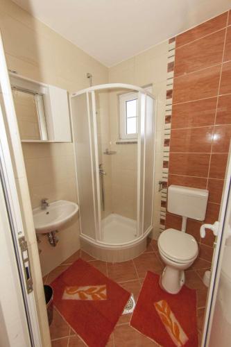 a bathroom with a toilet and a shower and a sink at Apartments Simovic in Tučepi