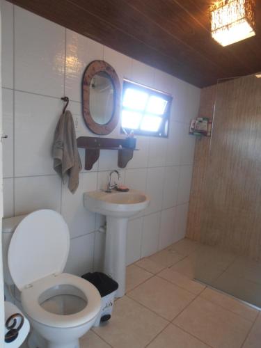 a bathroom with a toilet and a sink and a mirror at Casa de Gabi in Lençóis