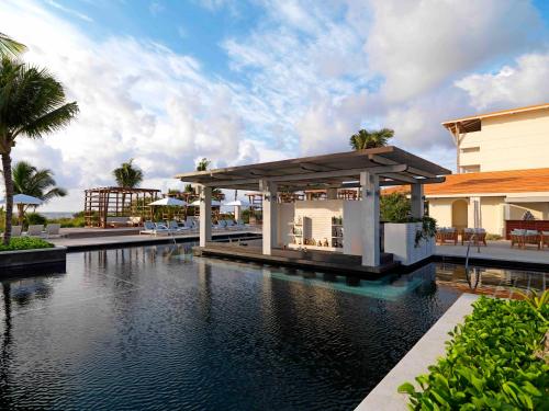 a swimming pool with a pavilion next to a building at Unico Hotel Riviera Maya Adults Only in Akumal