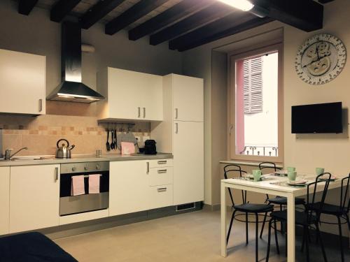 a kitchen with white cabinets and a table and a window at Niki O. Apartments in Parma