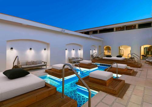 a hotel room with four beds and a pool at Unico Hotel Riviera Maya Adults Only in Akumal